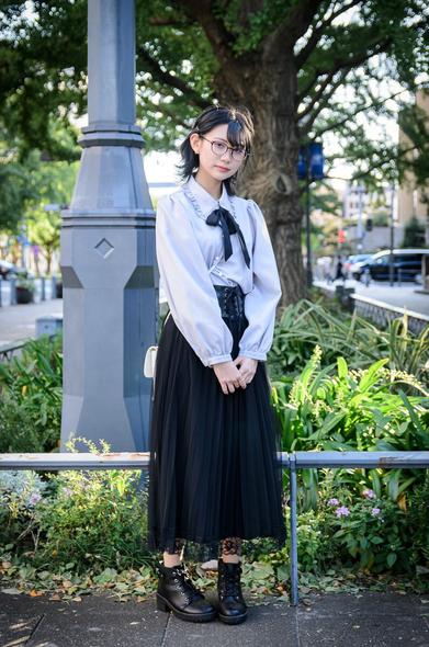 街路樹の前に立つ少女