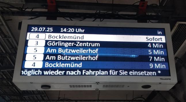Picture of an electronic announcer showing that the next two Trams in line 5 are coming in 5 and 7 minutes respectively even though the frequency should be 10 minutes. An announcement at the bottom (seen only partially) warns of delays in the line due to too much traffic.