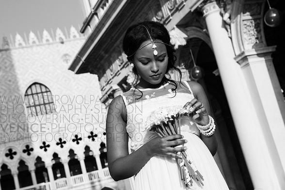 A bride basks in the sun and enjoys her bouquet in St. Mark's Square in Venice, Italy.