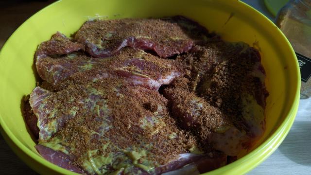 eine gelbe Schüssel voll marinierten Scheiben Halsgrat