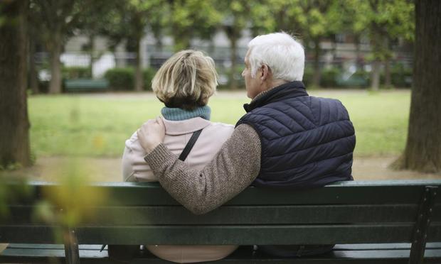 Una pareja de ancianos sentada en un banco público. (Getty Images)