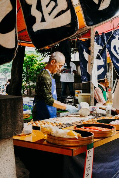 photo of an old man serving food at a street food booth