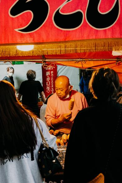 photo of an old man serving food at a street food booth