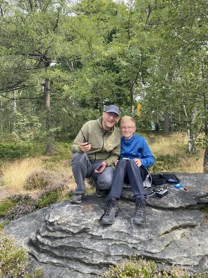 Two amateur radio radio operators working near a trail in the wooks