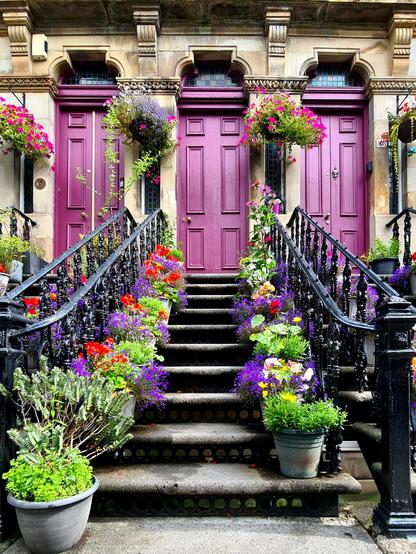 Stairs lines with flowers leading up the three doors on the ground floor of a Victorian tenement building in Glasgow