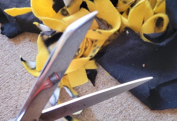 Sharpened shears in front of a pile of rags cut into tiny pieces