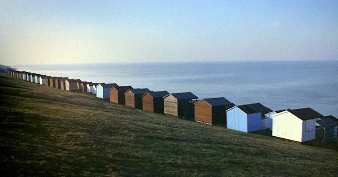 A row of colourful beach huts.