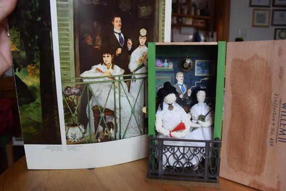 Ein geöffnetes Holzkistchen ist nach vorn zu einem Balkon erweitert, der von einem ornamentalen Schutzgitter aus Gusseisen umrahmt wird. Im Vordergrund sitzt eine weibliche Figur, die aus weißem Garn gehäkelt ist (die Malerin Berthe Morisot.) Ein roter Fächer hängt an ihrem Handgelenk. Ihr weißes Sommerkleid ist mit Spitzen besetzt und um den Hals trägt sie an einem schwarzen Band ein goldenes Medaillon. Ihre schwarzen Haare fallen in Korkenzieherlocken auf die Brust. Die zweite ebenfalls gehäkelte Figur (die Geigerin Fanny Claus) steht rechts auf dem Balkon, trägt ebenfalls ein weißes Spitzenkleid und hält einen zusammengefalteten grünen Sonnenschirm in ihren Händen.
Die Szene im Hintergrund ist gemalt und zeigt den rauchenden Maler Antoine Guillemet in einem eleganten schwarzen Anzug mit blauer Krawatte. Noch weiter im Hintergrund trägt ein Diener ein Gefäß mit einer leuchtenden Flüssigkeit – vielleicht Limonade -  in den Raum. An der Wand hängt unter anderem eine Briefmarke mit Hundemotiv, die auf das fehlende Hündchen im Original hinweist.