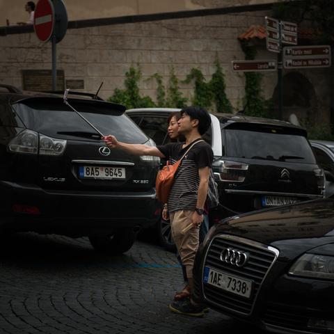 Portrait of a couple of asian tourists making a selfie in the streets of Prague