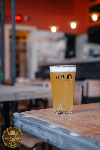 A glass of beer on the corner of a wooden table