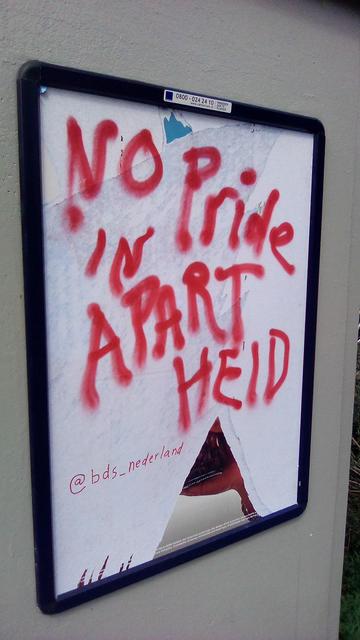 reclamebord verandert in witte achhtergond met rode spray letters: no pride in apartheid @bds_nederland
je ziet ong wat resten van de reclame, midden onder bijv een driehoek vorm
