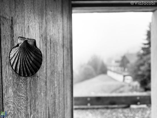The pilgrim shell engraved in the wooden door of the chapel.