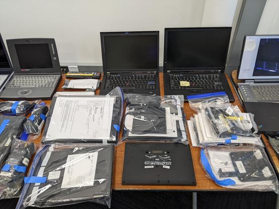 Another of my tables in the consignment room, with multiple thinkpads, dell laptops, a DEC 486 laptop, and other retro computing items