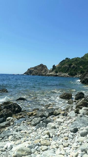 spiaggia di sassi e scogli con mare limpido
