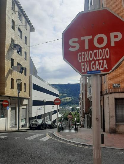 Sestaoko kale gurutze batean stop trafiko seinalean jarri dute "genocidio en Gaza" pegatina batekin. Atzerago, gurutzebideko beste aldean bi debeku seinale daude
