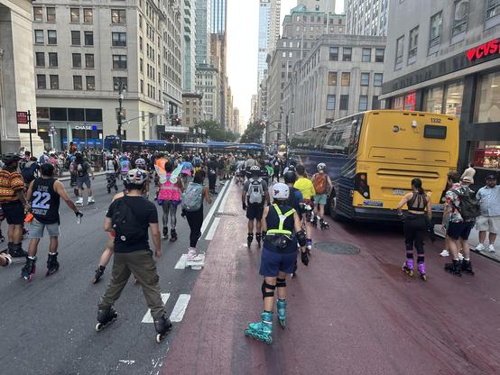Photo of many skaters rolling down Fifth Ave, shot from amongst them.