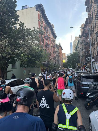 Photo of many skaters rolling down Thompson St, shot from amongst them. One WTC can be seen a mile or two ahead.