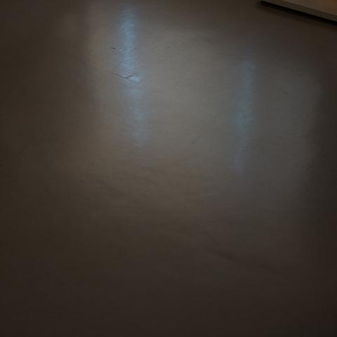 Abstract photo of a shadow on the floor, with just a ray of light