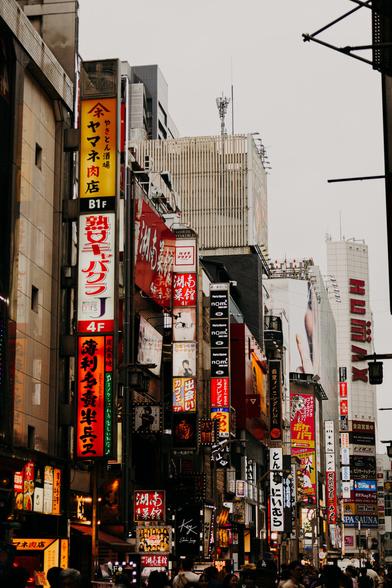 photo of various advertisement billboards at buildings on the side of a busy street