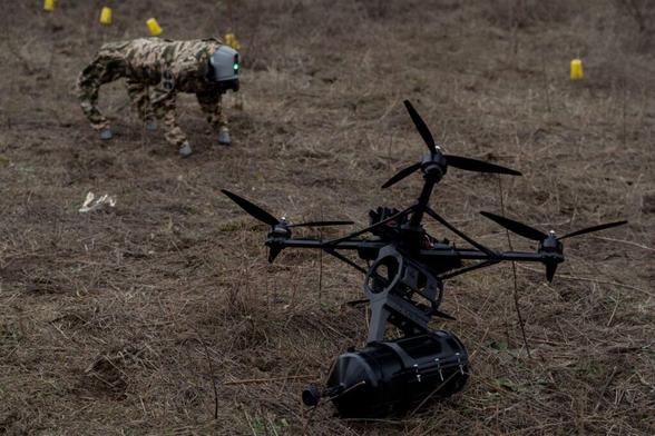 A robot dog walks through tests of drones using fiber optics to fly at an undisclosed location in Kyiv Oblast, Ukraine, winter 2024/25