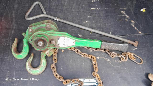A green Morris ratchet lever hoist rated at 1.5 ton. Also, a long handle drain cover lifting key.