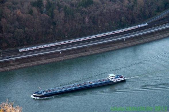 Frachtschiff auf dem Rhein und InterCity im Hintergrund.