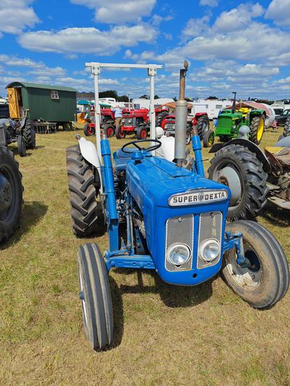 A rather square, chunky tractor with a very in-your-face nameplate. It has hydraulic arms and what looks like a very primitive anti-roll arch?