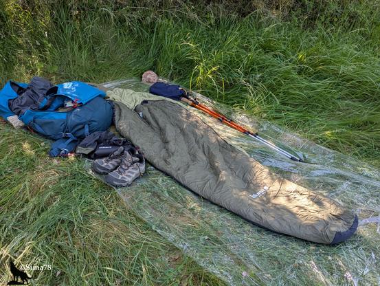 🇫🇷 Équipement de camping étalé sur l'herbe, incluant un sac de couchage, un sac à dos, des chaussures de randonnée et des bâtons de marche.
🇬🇧 Camping gear laid out on the grass, including a sleeping bag, a backpack, hiking boots, and trekking poles.
🇪🇸 Equipo de acampada desplegado sobre la hierba, que incluye un saco de dormir, una mochila, botas de senderismo y bastones de trekking.