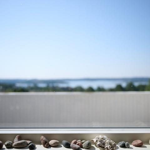 View outside a Window. Foreground: collected stones, background: typical swedish surrounding with sky and sea