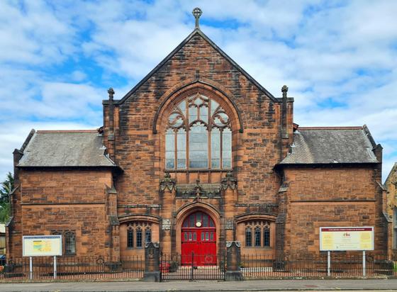 A symmetrical red sandstone Edwardian church in Glasgow.