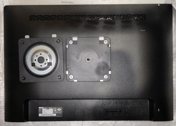 Foto der Rückseite eines BenQ BL2201PT-Modells, welches den erwähnten Adapter zeigt, der entfernt wurde und neben der VESA MIS D-Aufnahme liegt. Diese liegt dadurch etwa 1 cm tiefer als die restliche Gehäuserückwand.
