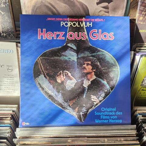 Alternate album cover features a still photograph from the film inside a heart- shaped glass object.