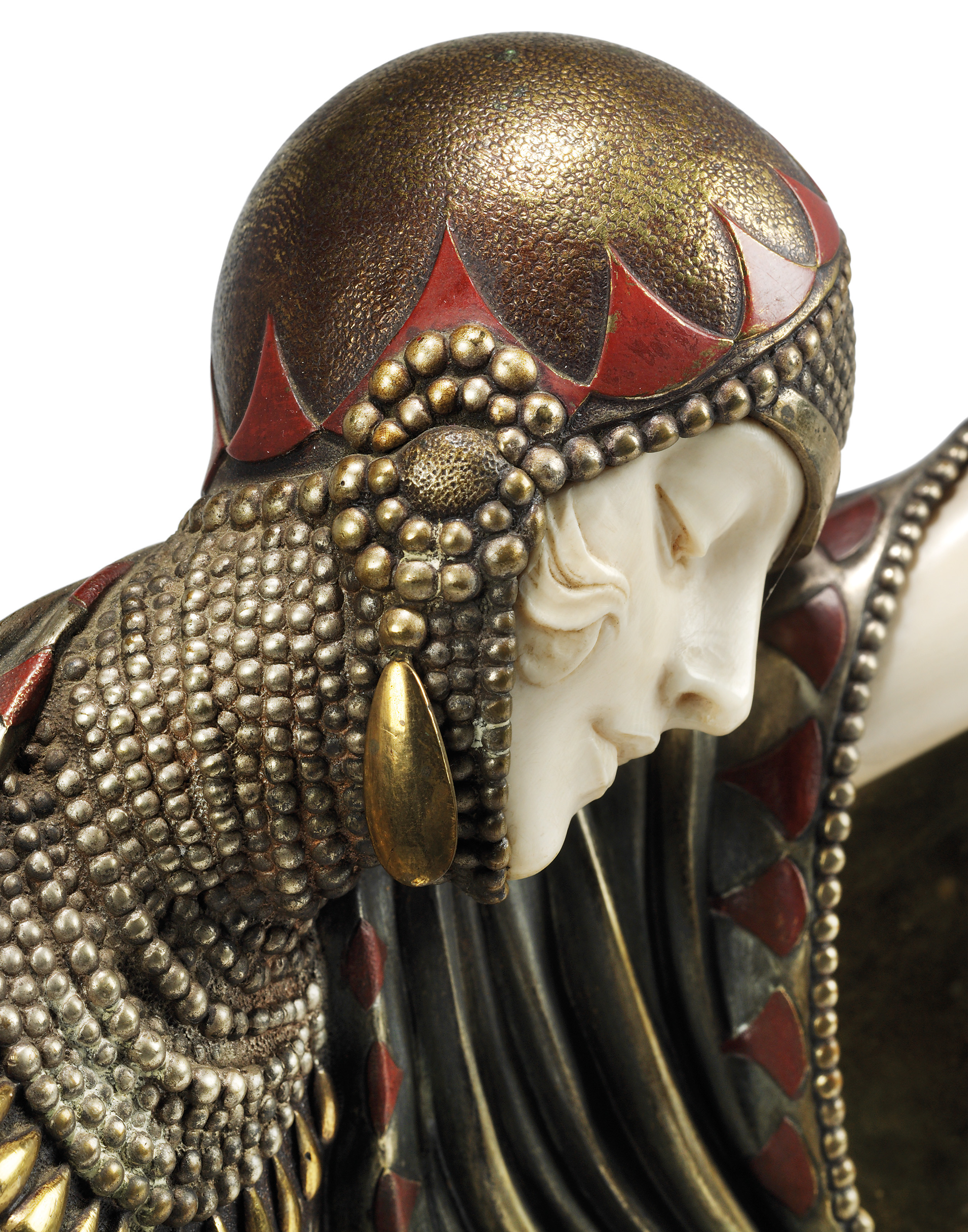 Closeup of a woman’s head, wearing a  richly decorated close-fitted cap.