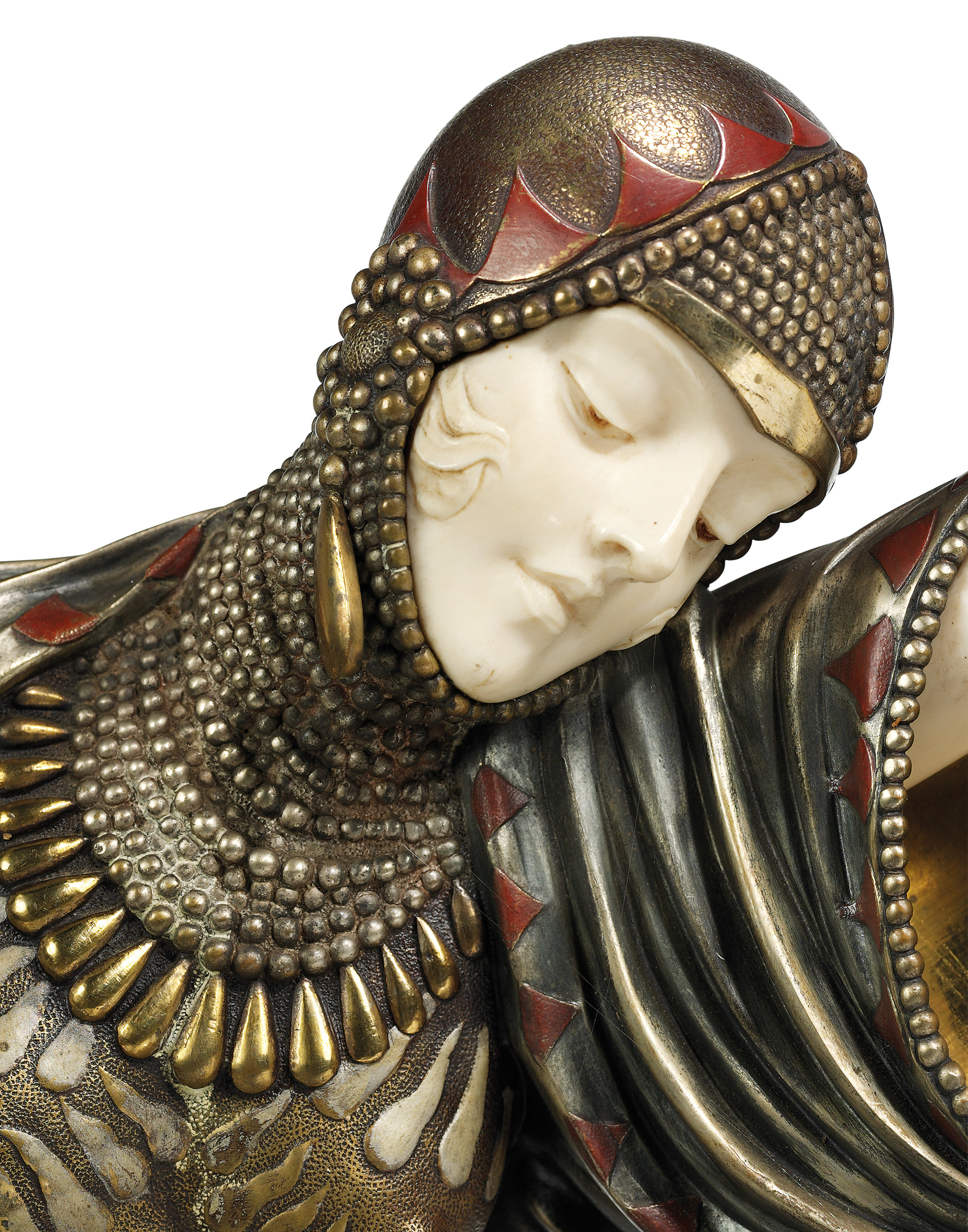 Closeup of a woman’s head, wearing a  richly decorated close-fitted cap.