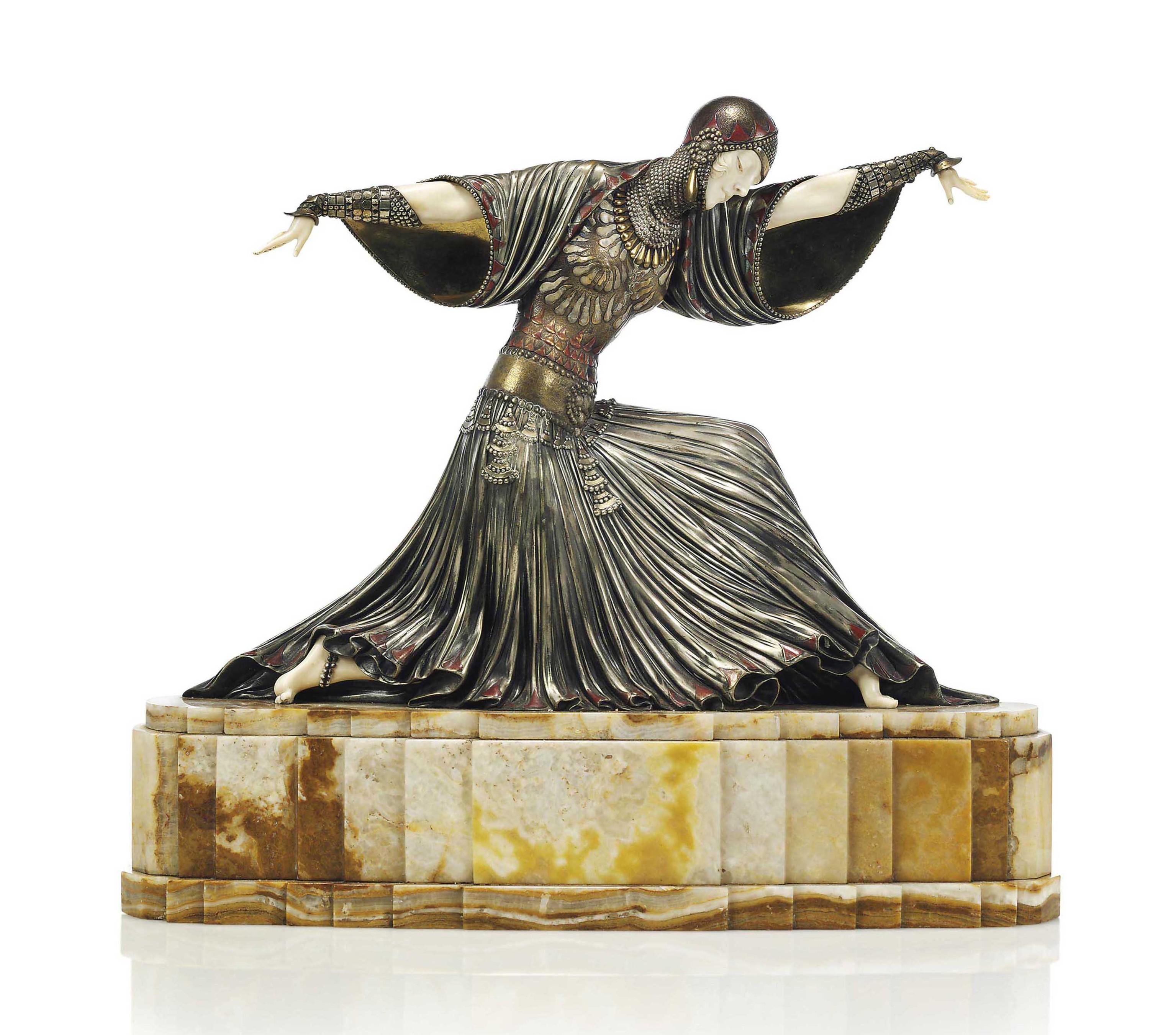 From a listing by Bonhams London: “Thais' a Rare Art Deco Patinated Bronze and Carved Ivory Model of an Exotic Dancer, circa 1925 she is depicted posing on one knee with arms outstretched, dressed in pleated costume with draped sleeves, her figure hugging bodice enhanced with raised ornamentation, her neck encrusted with layers of necklace in a silver patination, raised off an elaborate marble base.”