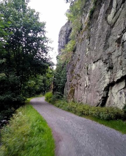 Die Steinach-Klamm entlang: vorne schlängelt sich der Schotterweg, links einige Bäume, rechts türmen sich steile Felsen empor.