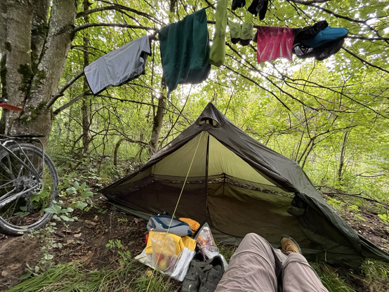 Tent in the woods, clothes drying above