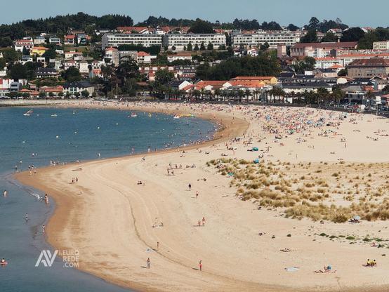 En la imagen puede verse un playa gallega con mucha gente en la zona superior.
