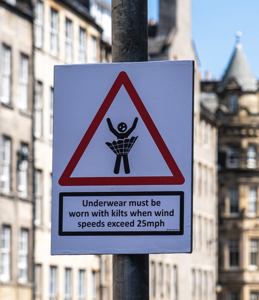 A poster on Edinburgh's High Street reads "Underwear must be worn under kilts when wind speed exceeds 25mph."