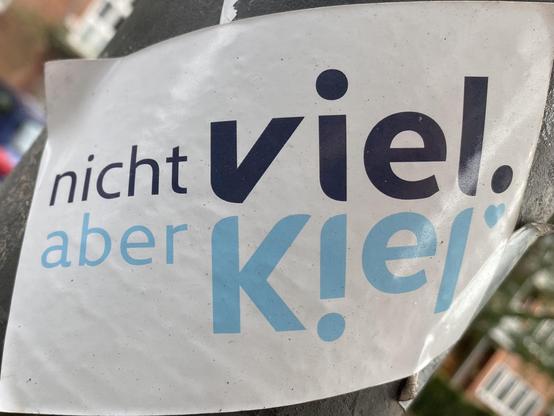 Sticker mit dem Design der Stadt Kiel an einer Laterne: "Nicht viel aber Kiel".