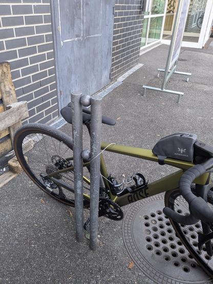 Expensive road bike locked to a stall with a combination luggage lock.