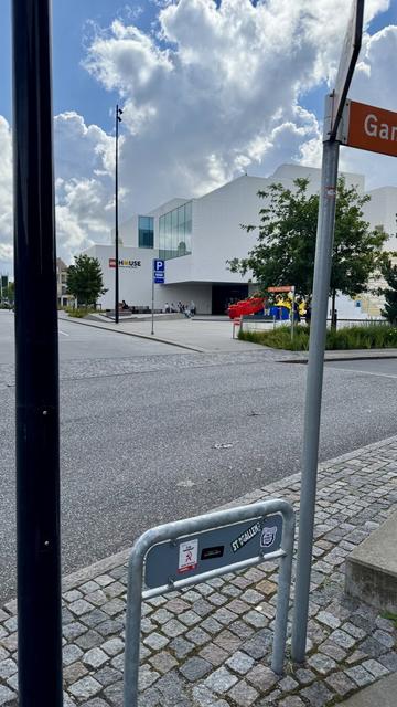 Sticker on the back of a road sign representing a cartoonish hand linked to foot by a black limb and is ticking the foot with a feather. The text on the sticker says «  The Vicious Cycle » by NoeGrit
