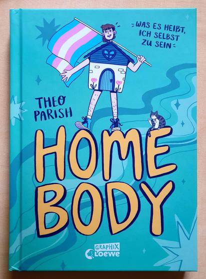 Buchdeckel von Home Body - Was es heißt ich selbst zu sein von Theo Parish, vom Graphix Loewe Verlag. Vor türkisem Hintergrund, gezeichnet, eine Person mit einem kleinen Häuschen als Körper, Beinen mit Sportshuhen und einer wehenden trans Flagge in der Hand. Auf dem Buchstaben E des Titels ein Kätzchen.