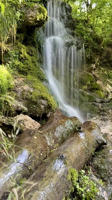 A small waterfall cascading over moss-covered rocks.