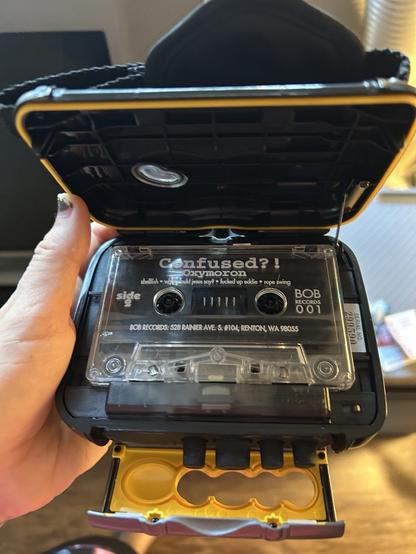 Somy Walkman with a cassette tape in it, open and exposed. The tape is confused?! by Oxymoron (I don’t know this band - it’s just a free tape I have for testing)
