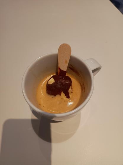 Eine Tasse in der ein Mini Magnum steht, dass von Espressi umspült wird.
