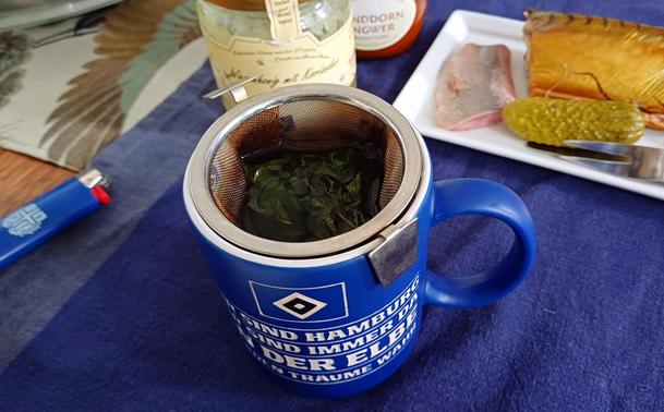 Frühstückstisch. Im Becher getrocknete Zitronenmelisse-Blätter