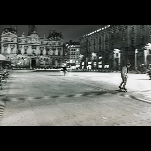 By night, black and white photo of a rollerskater in the place des terreaux, Lyon 1er ,France