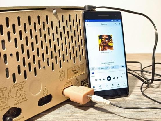 Smartphone Audio über NF-TA Stecker von Neufeldt & Kuhnke an Philips Philetta angeschlossen.
Das Display zeigt den MP3 Player, der ein afrikanisches Lied abspielt.