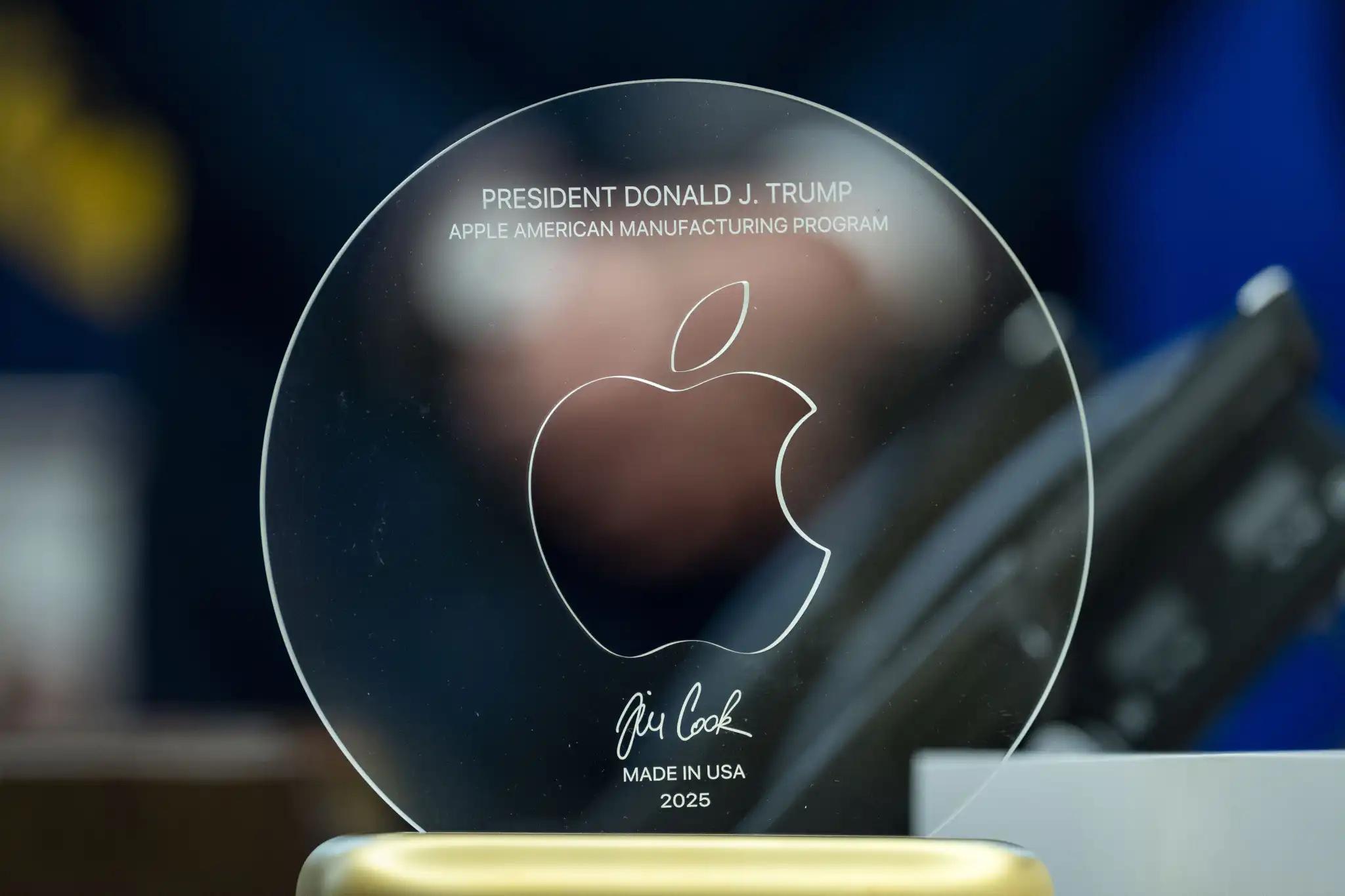 Glass disk in a gold stand, etched with a giant Apple logo and the text: “PRESIDENT DONALD J. TRUMP APPLE AMERICAN MANUFACTURING PROGRAM” Tim Cook’s signature “MADE IN USA 2025”